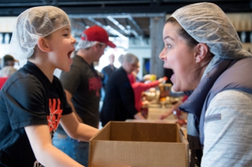 LINCOLN, NEB. - 01/13/2018 - Holden Pavlish, 6, and Ashley Pavlish, right, yell "BOX" Sunday, Jan. 13, 2018, after packaging 36 meal bags to signify they are one step closer to making 10,000 meals. KAYLA WOLF, Journal Star